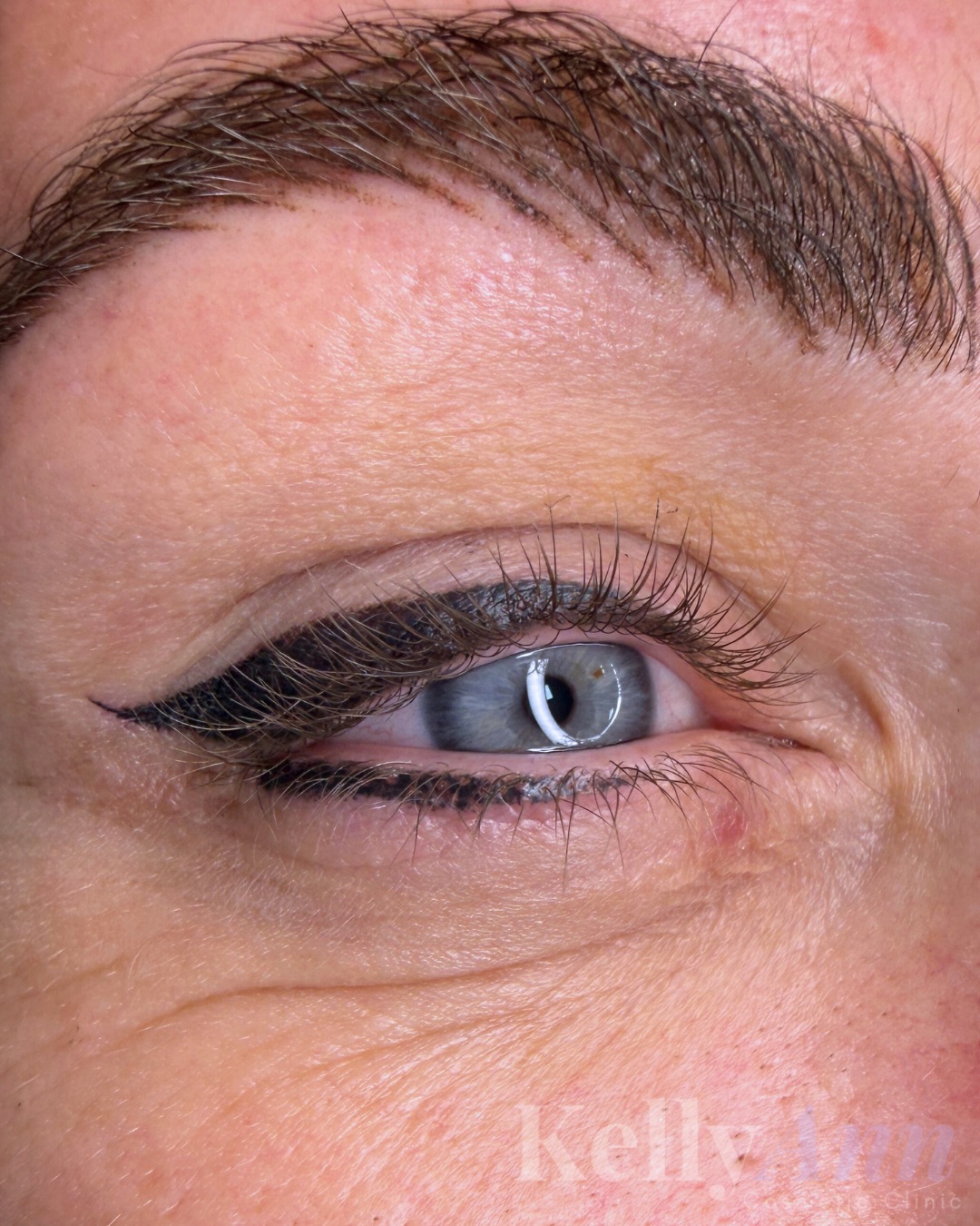 Healed winged permanent eyeliner and soft brow on a client with blue eyes
